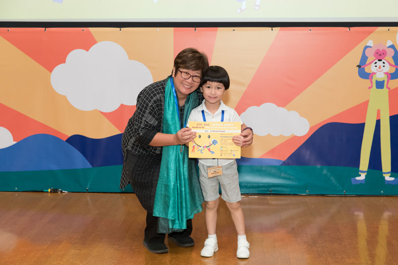 書伴我行（香港）基金會社區閱讀發展總監蔡淑玲女士頒發獎狀予幼兒組入圍者關錦珒小朋友。